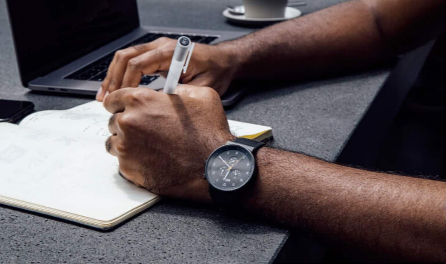 man writing down meeting notes